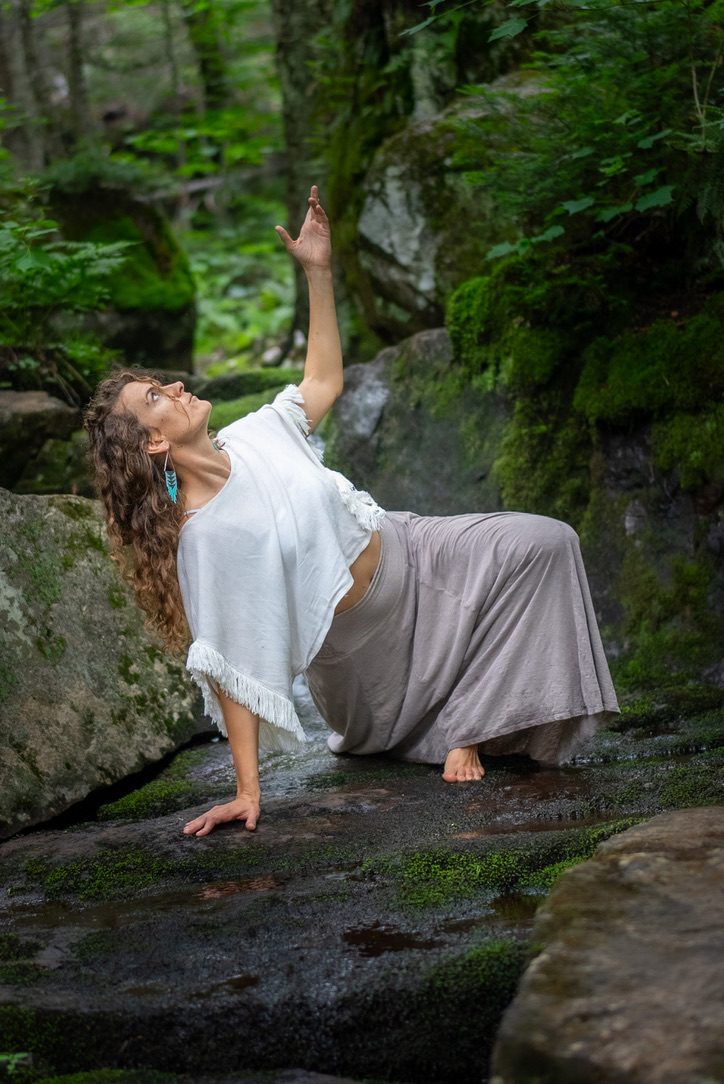 Robyn reaching toward the light in the forest